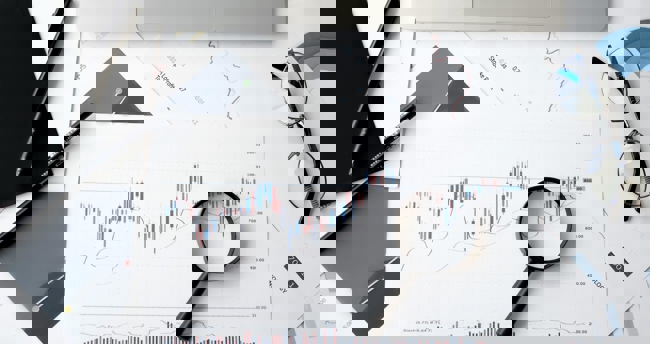 Beeld van financiële analyse in een zakelijke omgeving, met focus op grafieken en financiële gegevens.