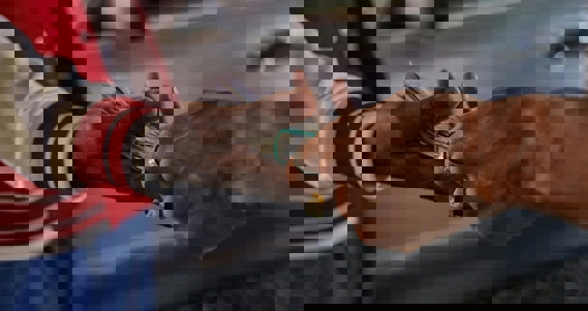 Een persoon overhandigt geld aan een andere persoon in een formele setting.