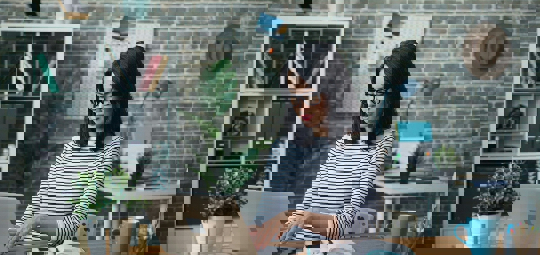 Een vrouw met een bril werkt geconcentreerd op haar laptop.